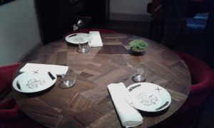 I tavoli, progettati da Martino Gamper, sono appositamente lasciati senza tovaglia per non coprire la sua opera.