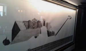 Disegno a mano libera che è stato ritrovato a fare da spessore sotto la gamba di un tavolo. Rappresenta la vista su piazza Carignano. E' stato ingrandito e affisso in una piccola sala, l'unica a non avere la vista sull'autentica piazza.